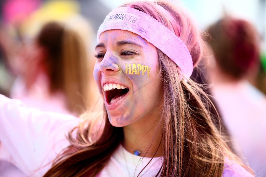 BRIGHTON, ENGLAND - OCTOBER 10: Runners celebrate in the Festival Area after The Color Run presented by Dulux on October 10, 2015 in Brighton, England. The Color Run took place at Brighton's Madeira Drive on 10th October 2015, known as the 'Happiest 5k on the Planet', thousands of 'Color Runners' were covered in coloured powder as they ran the 5km course. (Photo by Jordan Mansfield/Getty Images for Color Run)